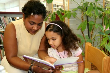 Mother Reading Book to Daughter